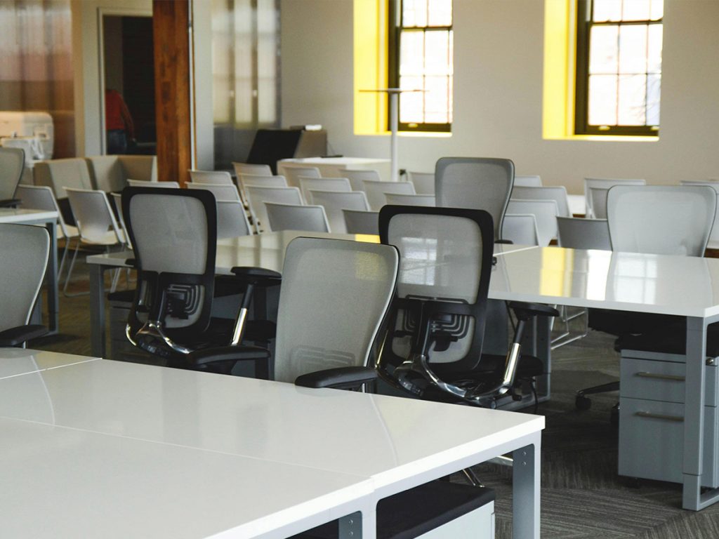 Gepflegtes, leeres Großraumbüro in Nürnberg mit weißen Schreibtischen und Bürostühlen nach der Reinigung